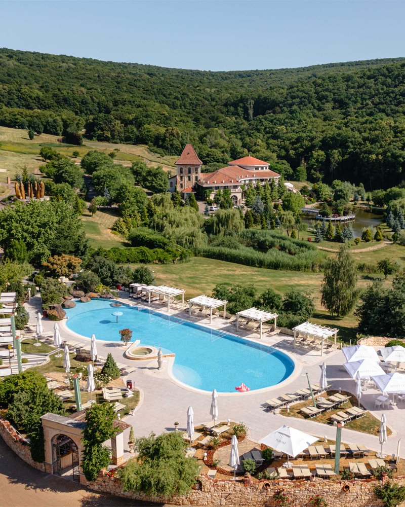 An aerial view of the outdoor pool and landscaped grounds at SunGarden Golf & Spa Resort near Baciu.