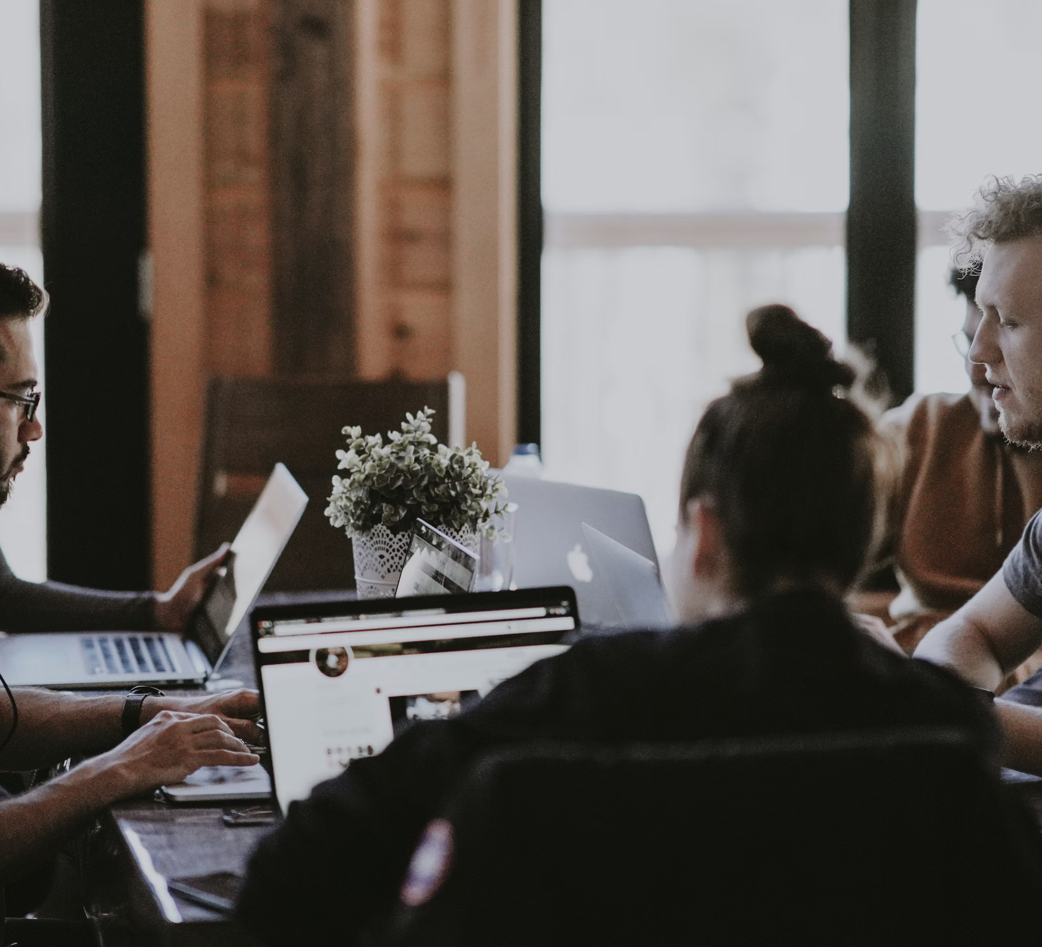 People working together around a table with laptops.